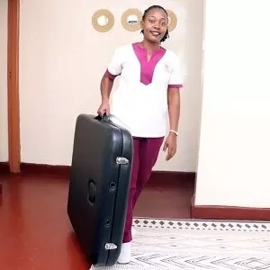 A mobile massage therapist with Viv's in-Houz spa poses with a massage table in Nairobi