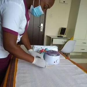 A waxing professional prepares the waxing table and the waxing materials ready for waxing procedure in Nairobi